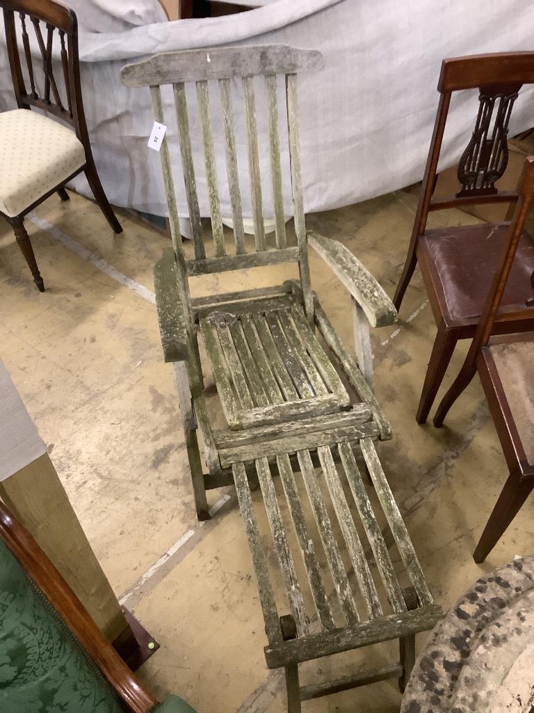 A weathered teak folding garden steamer chair